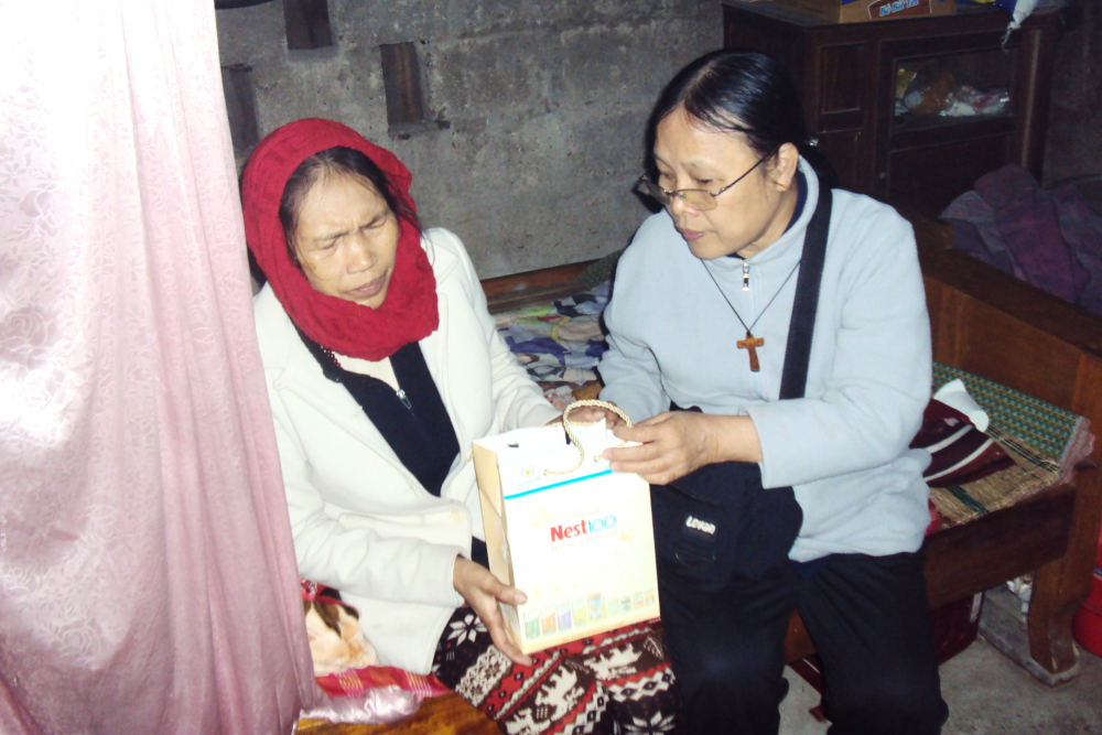 Gift to a patient Sr. Mary Vu Thi Ngoc (right) offers a gift to a patient who suffers from domestic abuse on Mar. 6 in Phong Dien district of Thua Thien Hue province, Vietnam. (Joachim Pham)