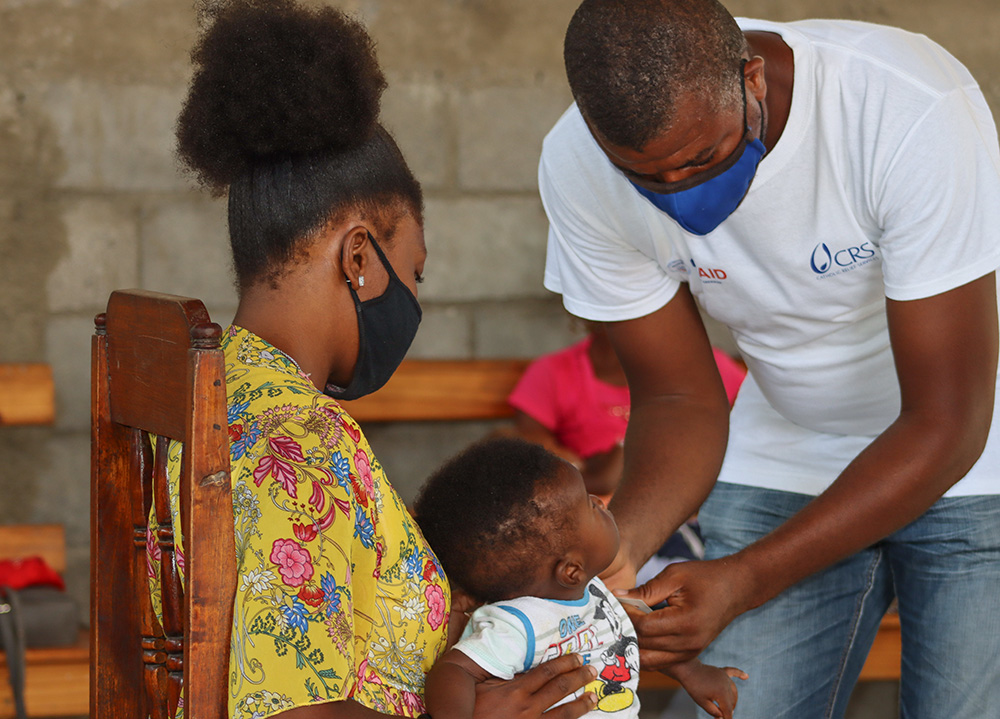 A worker with Catholic Relief Services assists a mother with her baby for a nutrition screening in Port-au-Prince, Haiti, July 20, 2020. (OSV News/Catholic Relief Services)
