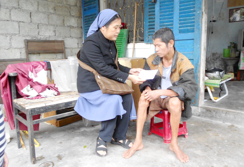 Sr. Mary Pham Thi Phu offers gifts to a man in Phu Loc District in Thua Thien Hue Sr. Mary Pham Thi Phu offers gifts to a man in Phu Loc District in Thua Thien Hue