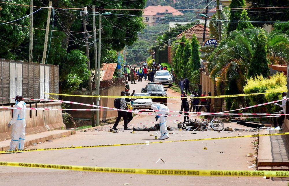 Forensic experts secure the scene of a bomb blast near the Munyonyo Martyrs' Catholic Shrine in the Munyonyo suburb of Kampala, Uganda June 3.