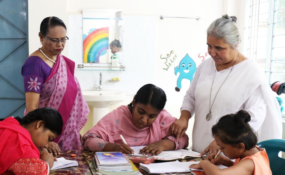 Sr. Nita Rozario with children at table  Sr. Nita Rozario with children at table