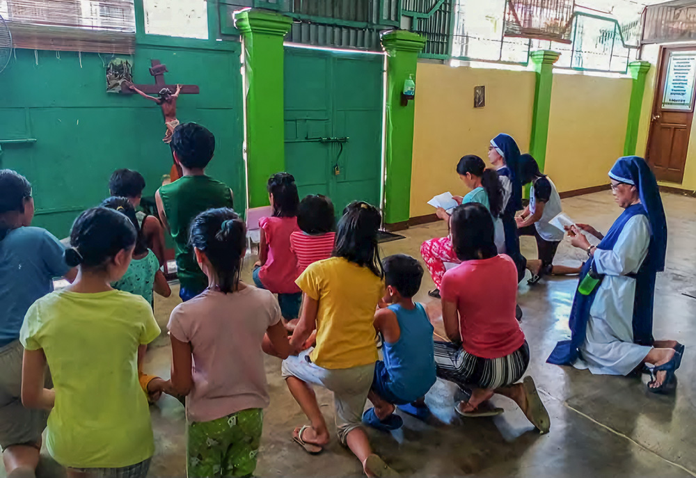 A group of children pray together with the sisters in the Holy Trinity Home for Children, an orphanage dedicated to caring for sexually abused and impoverished children. (Courtesy of Trinitarian Handmaids of the Divine Word)