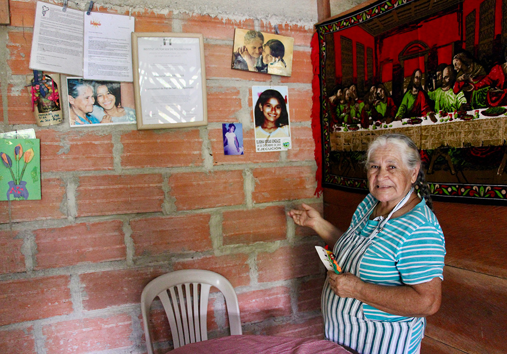 Brígida González, de la Comunidad de Paz de San José de Apartadó (Colombia), ante el Muro de la Memoria dispuesto en su casa. (Foto: Tracy L. Barnett) Brígida González, de la Comunidad de Paz de San José de Apartadó (Colombia), ante el Muro de la Memoria dispuesto en su casa. (Foto: Tracy L. Barnett)