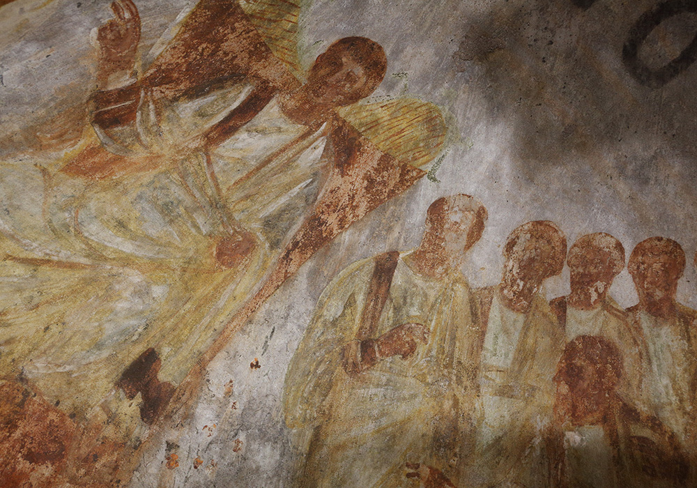 Jesus is seated on a throne with his disciples at his side in this fresco seen during the unveiling of two newly restored burial chambers in the Christian catacombs of St. Domitilla in Rome on May 30, 2017. (CNS/Carol Glatz)