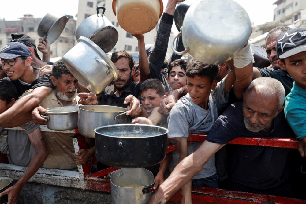 Palestinians gather to receive food from a charity kitchen amid a hunger crisis Palestinians gather to receive food from a charity kitchen amid a hunger crisis in the central Gaza Strip July 29, 2025. (OSV News photo/Hatem Khaled/Reuters)