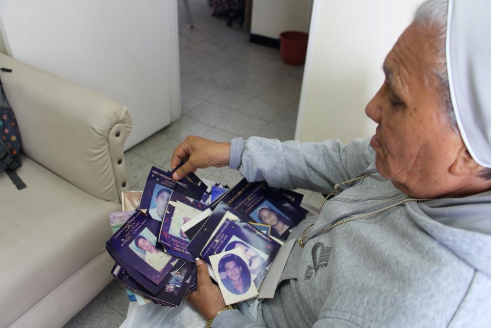 Sr. Rosa Cadavid looks at photos of victims of violence. Sr. Rosa Cadavid looks at photos of victims of violence.