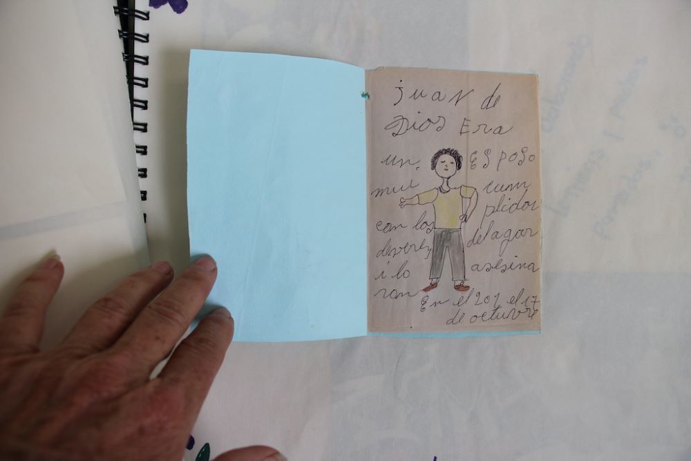 Sr. Rosa Cadavid holds a booklet a woman made to honor a devoted husband, Juan de Dios.  Sr. Rosa Cadavid holds a booklet a woman made to honor a devoted husband, Juan de Dios.