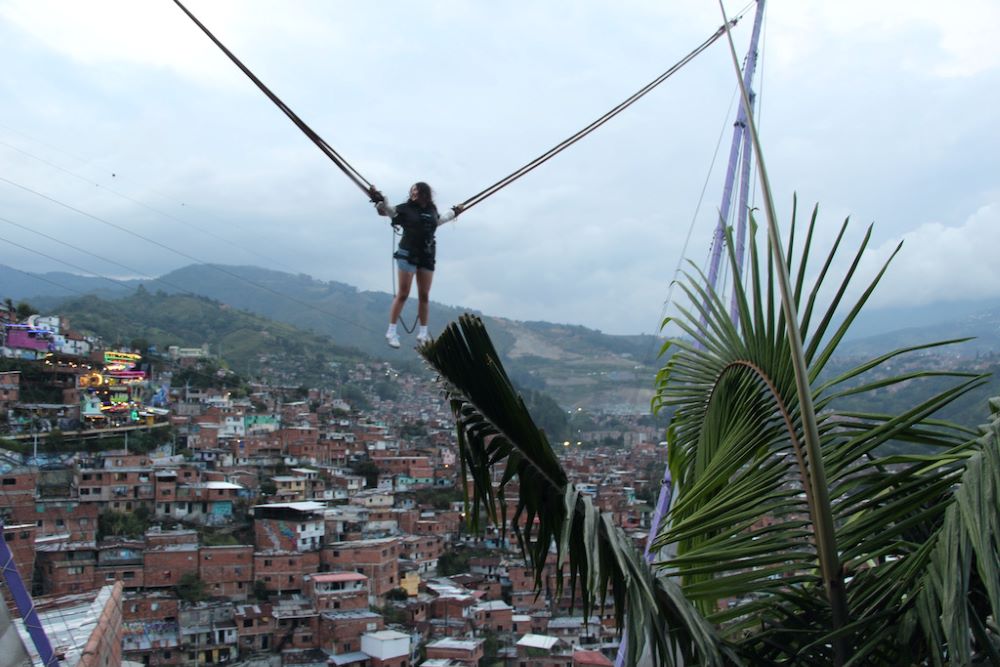 A tourist bounces on a bungee trampoline on a boardwalk-like strip at the top of the hill in Medellín, Colombia.   A tourist bounces on a bungee trampoline on a boardwalk-like strip at the top of the hill in Medellín, Colombia.