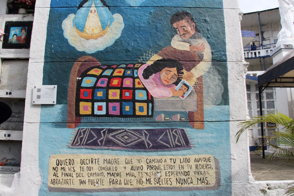 A mural in the Comuna 13 cemetery in Medellin shows mother and child. "I want to tell you, Mother, that I walk beside you even if you don’t see me," reads the inscription. A mural in the Comuna 13 cemetery in Medellin shows mother and child. "I want to tell you, Mother, that I walk beside you even if you don’t see me," reads the inscription.