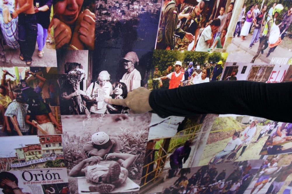 Carmen Jiménez points to a collage of photographs at Museo Comuna 13 in Medellin, Colombia. Carmen Jiménez points to a collage of photographs at Museo Comuna 13 in Medellin, Colombia.