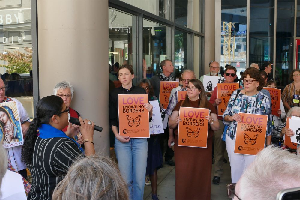 People participate in a vigil for immigrants and refugees.
