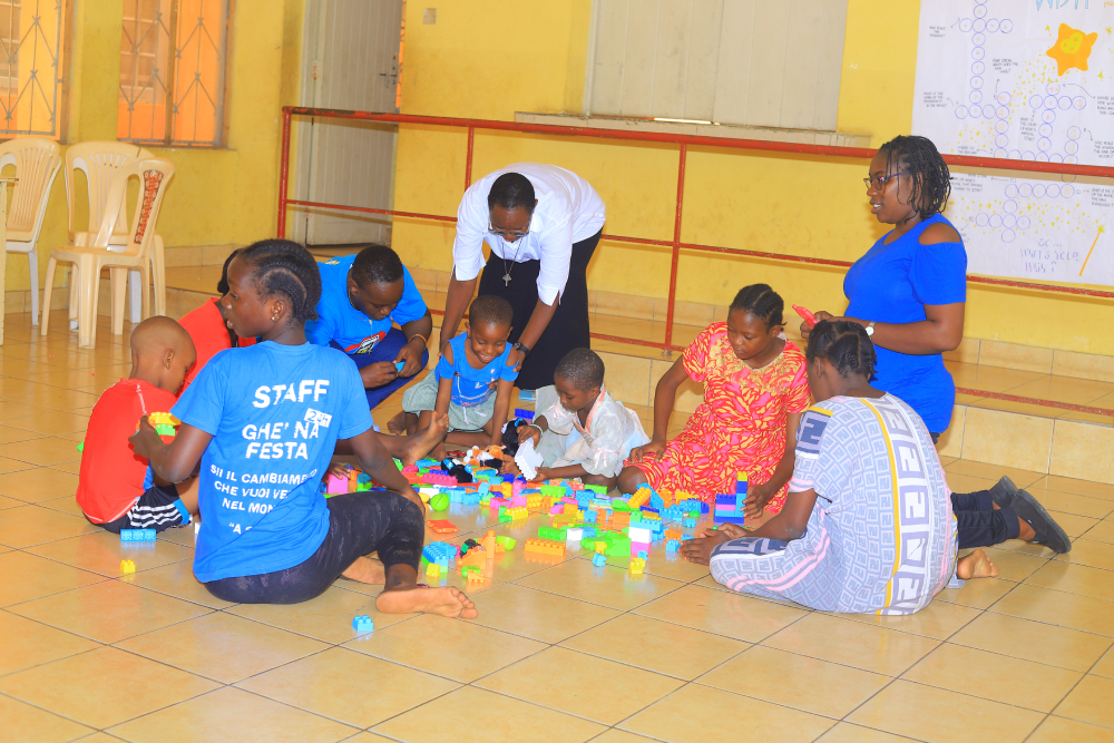 Children play with building blocks Children gather on the tiled floor for a group building activity led by caregivers and sisters.  (GSR photo/Doreen Ajiambo)