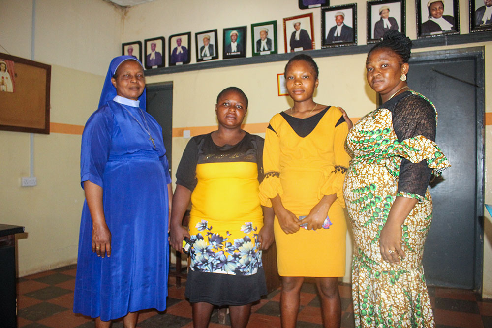Sr. Chioma Onyenufoh, far left, and Kelechi Agu, far right, both in the welfare department of the Catholic Institute for Development, Justice and Peace, pose for a photo with pro bono beneficiaries Chioma Onwuniko and Chinaza Obi. (Valentine Benjamin)