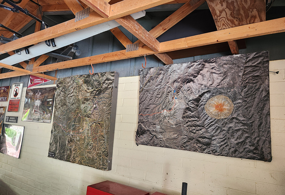 A to-scale model of Oak Flat hangs on the wall of the garage of Henry Muñoz, chairman of the Concerned Citizens and Retired Miners Coalition, in this April 24, 2025, photo. The model, based on the U.S. Forest Service's environmental impact statement, displays how a proposed copper mine would alter the geography around Superior, Arizona, including creating a crater the size of the Eiffel Tower at Oak Flat, a sacred site for Apache and other Native tribes. (NCR photo/Brian Roewe)