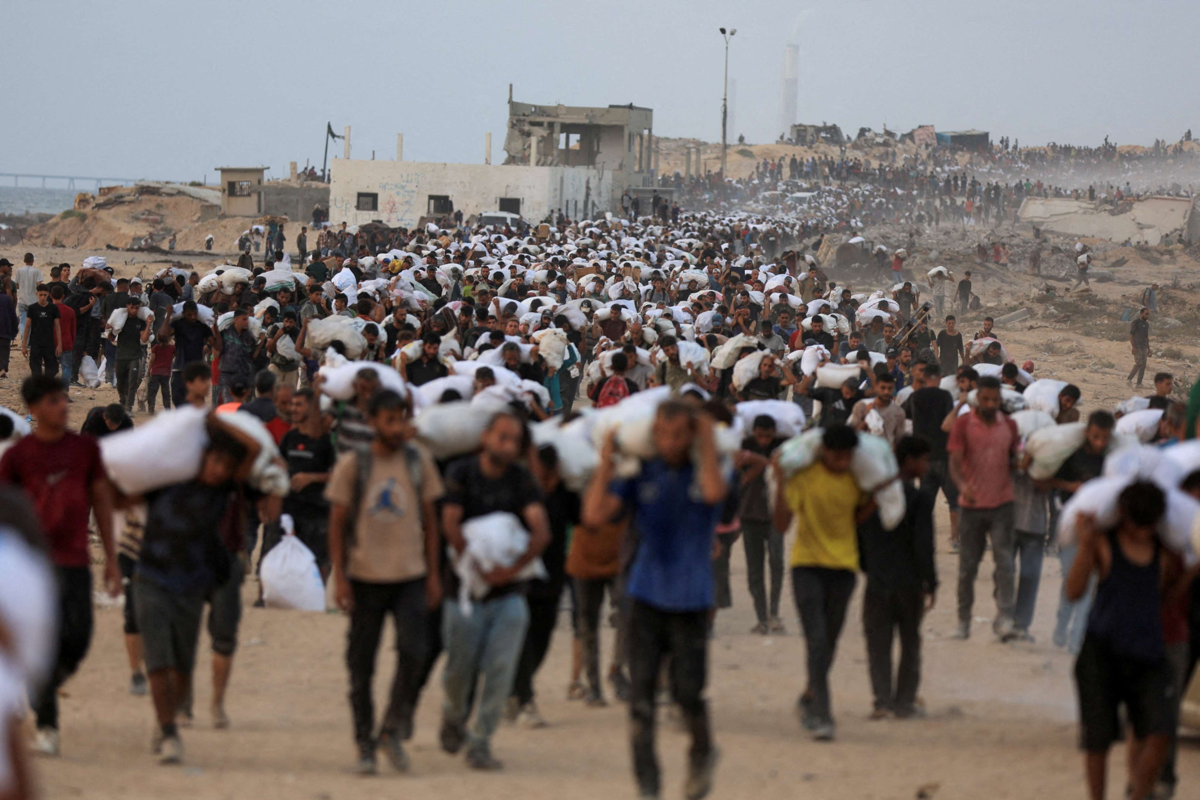 Palestinians carry humanitarian aid supplies that entered Gaza by truck through Israel, in Beit Lahia, in the northern Gaza Strip July 29, 2025. Despite enormous difficulties, Catholic Relief Services and its on-the-ground  partners have managed to deliver aid to 1.7 million people in Gaza since 2023, according to new data. (OSV News/Reuters/Dawoud Abu Alkas)