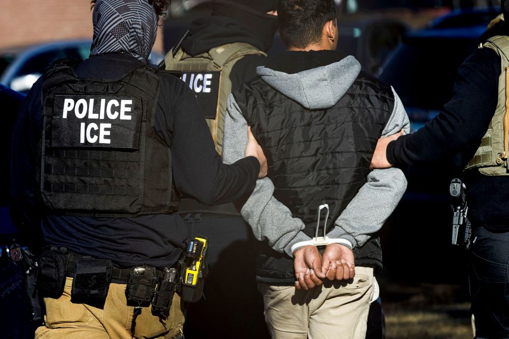 Agents with the Immigration and Customs Enforcement detain a man after conducting a raid at the Cedar Run apartment complex in Denver Feb. 5. 