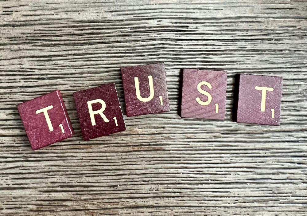 Scrabble tiles spell "trust." Scrabble tiles spell "trust."