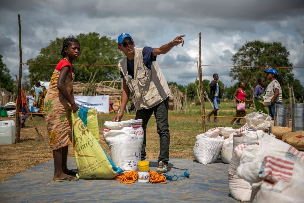 A Catholic Relief Services worker helps a young woman at a food distribution area in Marojela village, located in the Marolinta commune in southern Madagascar. 