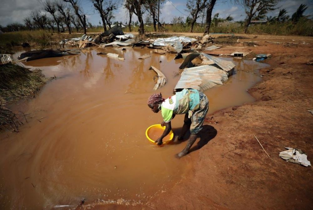 A woman collects water for washing amid receding floodwaters near Beira, Mozambique. 