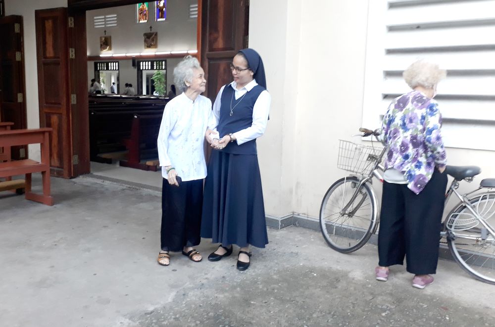Sr. Anna Huynh Thi Dien talks with an elderly woman. Sr. Anna Huynh Thi Dien talks with an elderly woman.