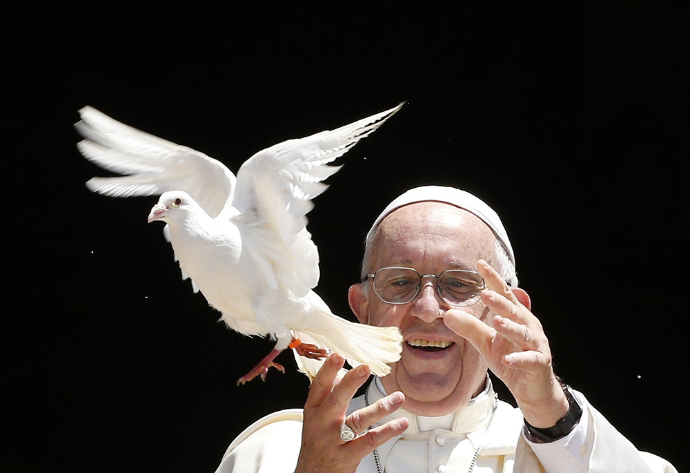 Pope Francis releases a dove outside the Basilica of St. Nicholas after meeting with the leaders of Christian churches in Bari, Italy, July 7, 2018, for an ecumenical day of prayer for peace in the Middle East. Daniel Horan writes that Pope Leo XIV is carrying the late Francis' message forward in his own teaching, urging all people to address the war on creation in our hearts and world. (CNS/Paul Haring)
