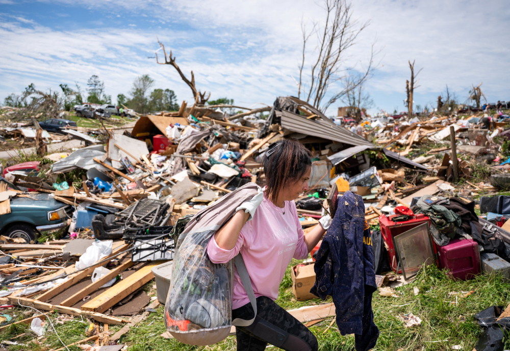 A woman carries belongings from a destroyed home in the Sunshine Hills neighborhood in London, Ky., May 18, 2025 A woman carries belongings from a destroyed home in the Sunshine Hills neighborhood in London, Ky., May 18, 2025, after a series of tornadoes hit the area May 16. At least 27 people were killed by storm systems that swept across part of the U.S. Midwest and South. (OSV News / Reuters / Seth Herald)