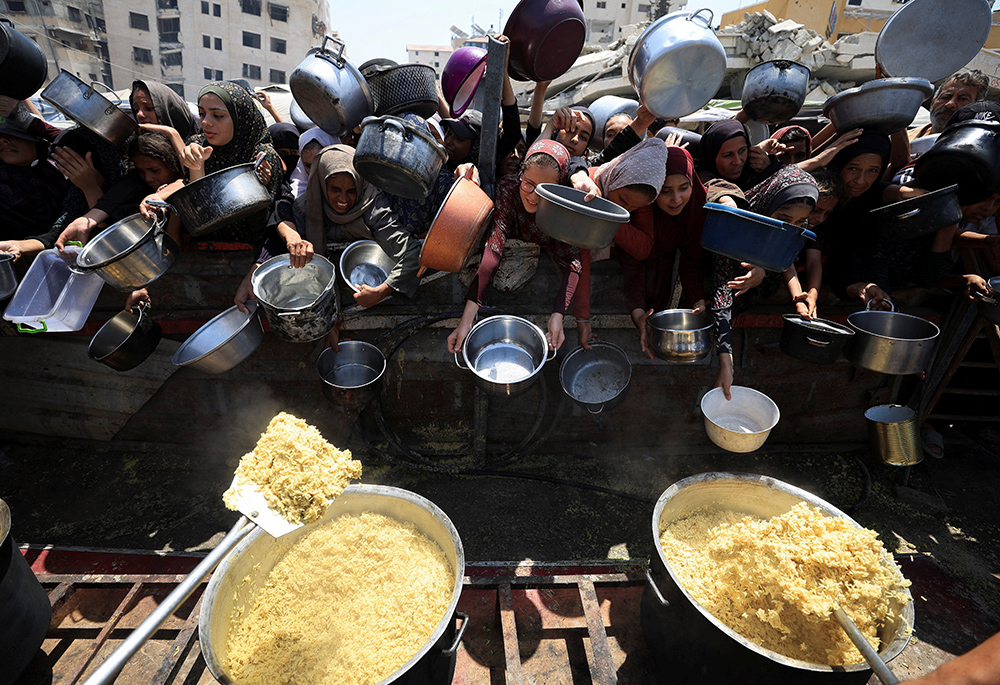 Palestinians wait to receive food from a charity kitchen in the Gaza Strip's Gaza City Aug. 15, 2025. (OSV News/Reuters/Dawoud Abu Alkas)
