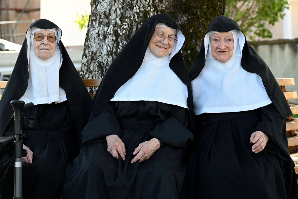 Augustinian Sisters Regina, 86; Rita, 81; and Bernadette, 88, sit on a bench at their old convent in Goldenstein castle in Elsbethen, Austria, near Salzburg Sept. 12. They refuse to return to their retirement home. (OSV News/Reuters/Angelika Warmuth)
