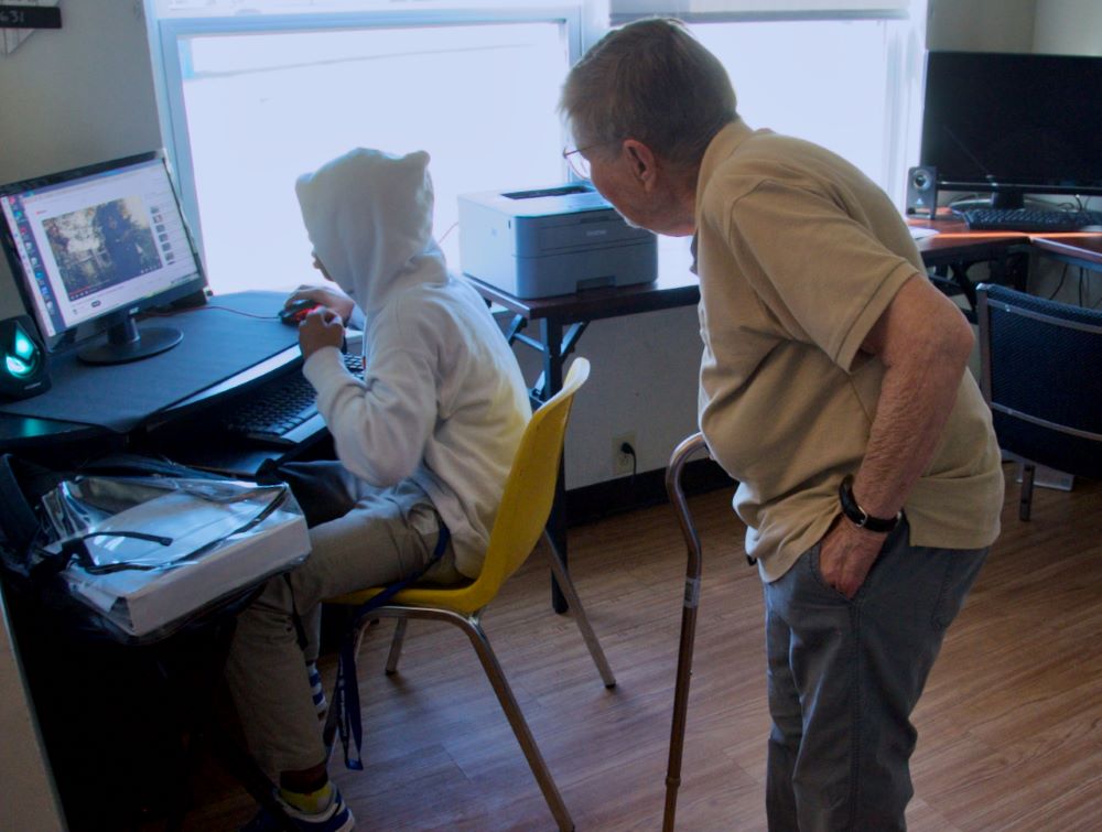 Sr. Julia Huiskamp helps a student use the computer. 
