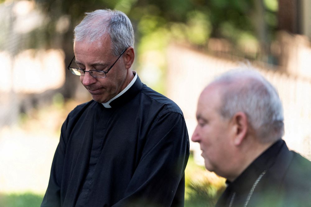 Fr. Dennis Zehren, pastor of Annunciation Church in Minneapolis, becomes emotional as he speaks to the media alongside Archbishop Bernard Hebda