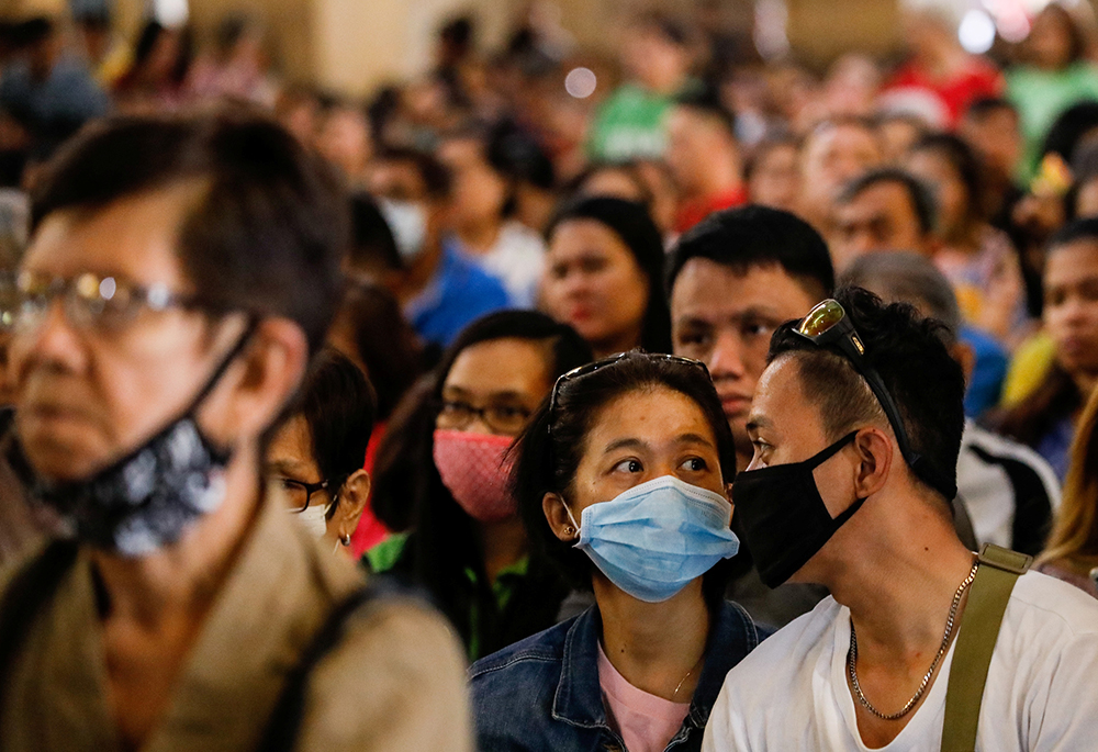 A couple wearing protective masks attend Ash Wednesday Mass at the National Shrine of Our Mother of Perpetual Help in Manila, Philippines, Feb. 26, 2020, amid the coronavirus outbreak. Sr. Alice Nyazungu writes: "My understanding of the Lenten season transformed significantly in 2020 during the COVID-19 pandemic." (CNS/Reuters/Eloisa Lopez)