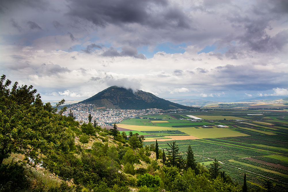 Clouds pass over Mount Tabor in the distance in Galilee, Israel. The mount is traditionally known as the site of Jesus' transfiguration. (Wikimedia Commons/Reutmaor)