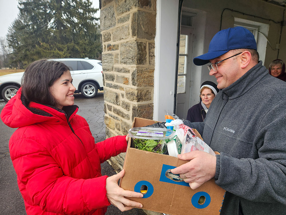 Fr. Vasyl Kopyn, right, is among those assisting St. Basil sisters in the distribution of food boxes to recent Ukrainian arrivals in the Philadelphia area. (GSR photo/Chris Herlinger)