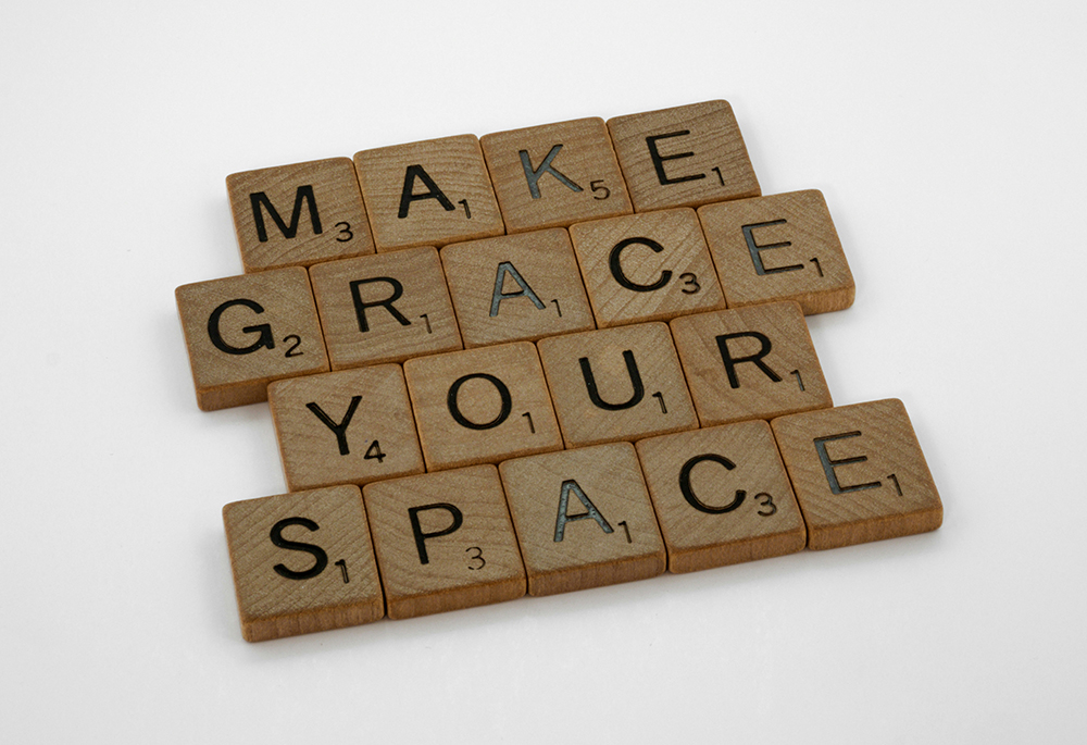 A photo illustration shows Scrabble-style wooden letter pieces, arranged to read "Make grace your space." (Unsplash/Brett Jordan)