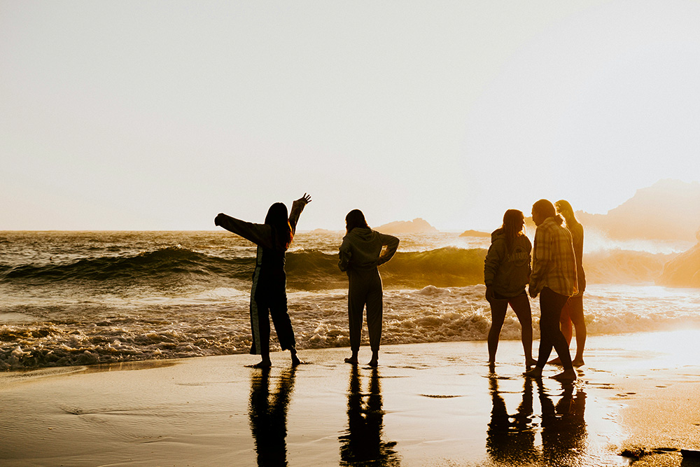 Silhouettes of five people by the ocean (Unsplash/Gabe Pierce)