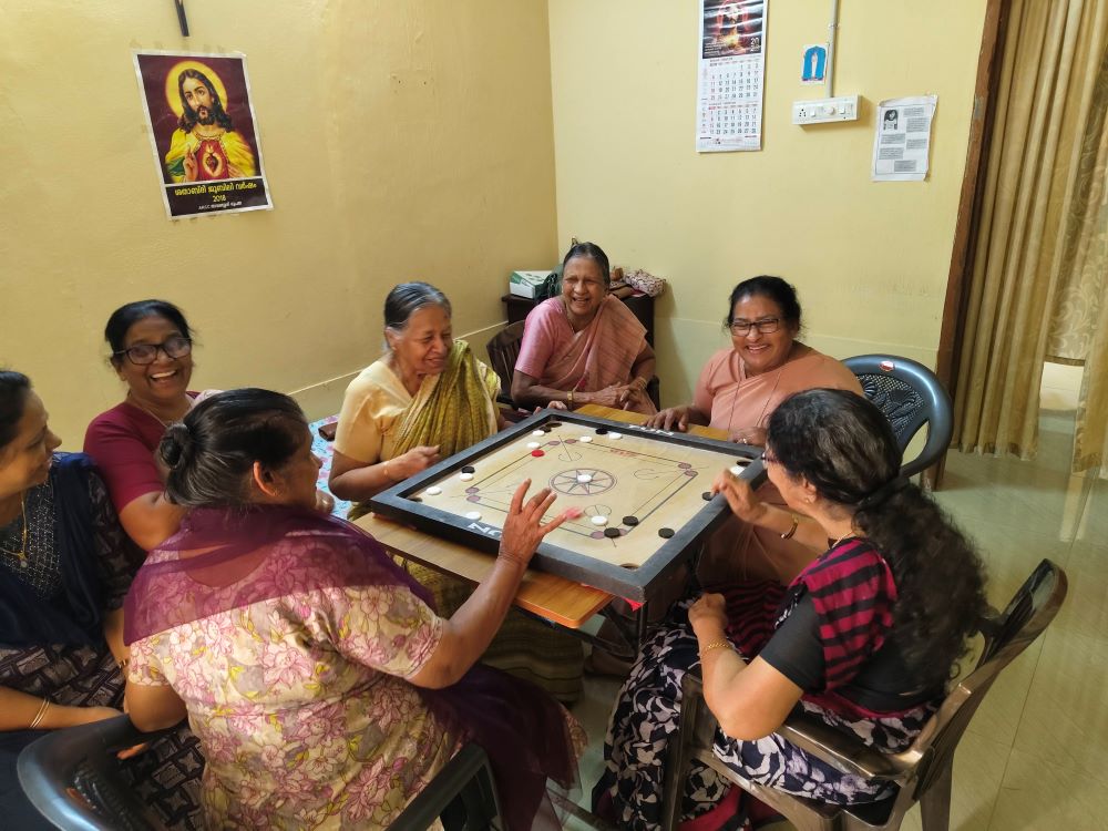 Nazareth Srs. Anice Vattukulam and Nisha Chemmanam (center) play carrom with the members of Asa Nilayam Pakal Veedu (Abode of Hope Day Home), a home for the elderly at Kallanode, a village in the Kozhikode district of Kerala, southwestern India. (George Kommattam)