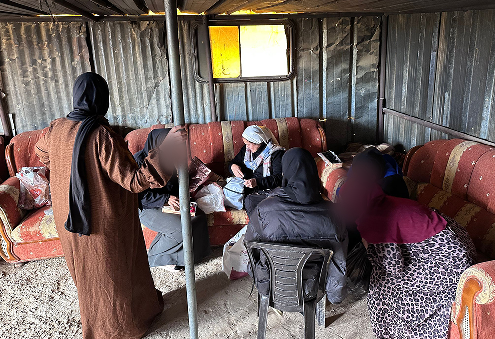 Women meet at the Tabana Bedouin camp near Al-Azariyeh, in the West Bank, for a "Threads of Peace" embroidery workshop on Feb. 28, 2026, as part of the Comboni sisters' accompaniment of Bedouin communities living with daily uncertainty. Sr. Maria Cecilia Sierra Salcido is pictured, white veil, center. The image is obscured to protect identity. (Courtesy of Sr. Maria Cecilia Sierra Salcido)