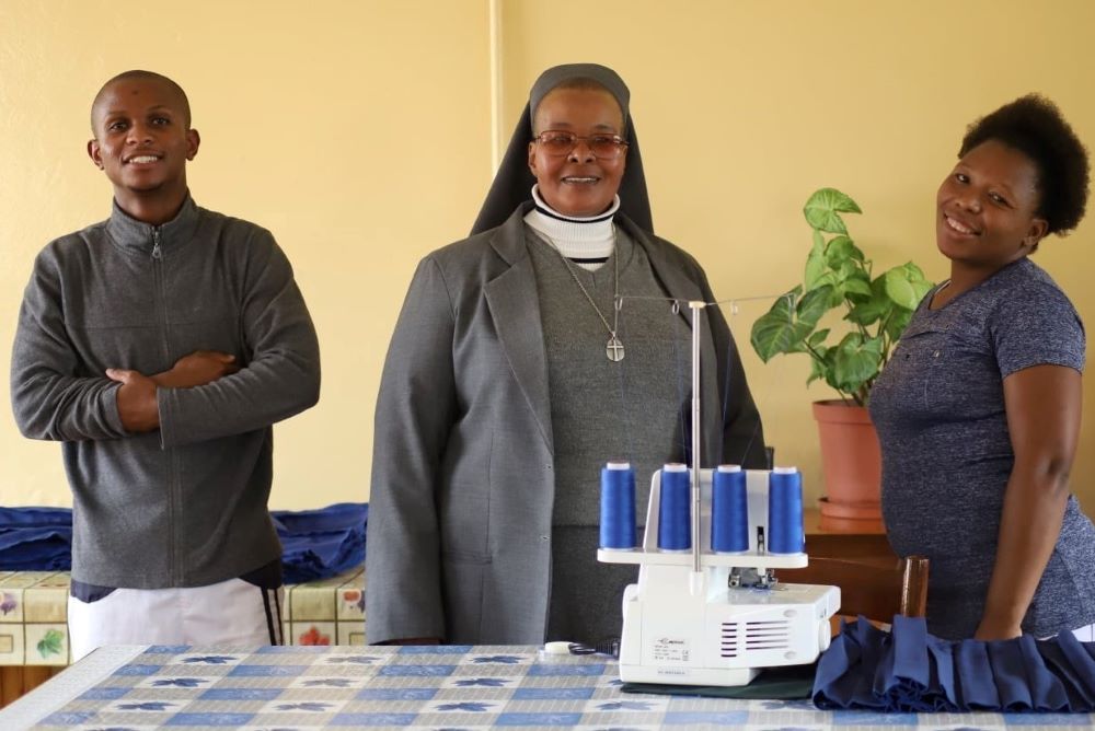 Sr. Victoria Mota, a member of Holy Family Sisters of Bordeaux-Lesotho, poses with students in the sewing room at the sewing center located at Holy Family High School in Leribe, Lesotho. (GSR photo/Doreen Ajiambo)
