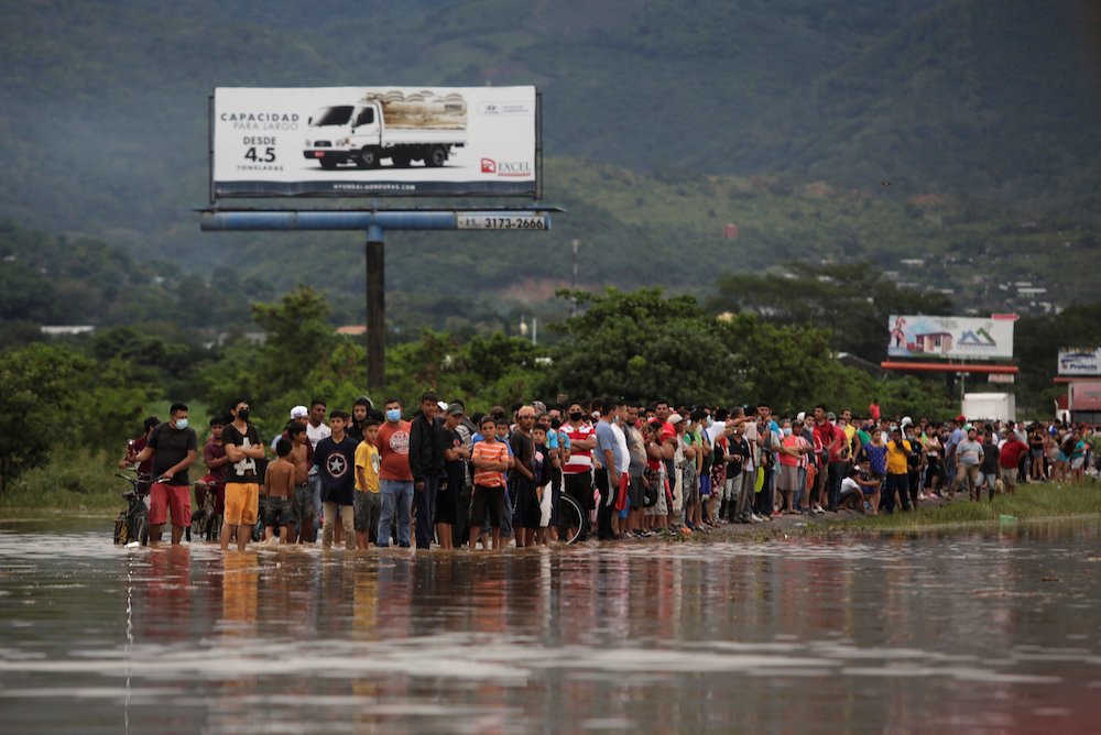 People stand alongside floodwaters in La Lima, Honduras, Nov. 5, in the remains of Hurricane Eta. (CNS/Reuters/Jorge Cabrera) People stand alongside floodwaters in La Lima, Honduras, Nov. 5, in the remains of Hurricane Eta. (CNS/Reuters/Jorge Cabrera)