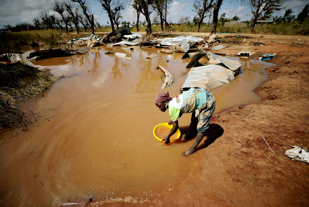 A woman collects water for washing as floodwaters begin to recede in the aftermath of Cyclone Idai near Beira, Mozambique, in March. (CNS/Reuters/Mike Hutchings) A woman collects water for washing as floodwaters begin to recede in the aftermath of Cyclone Idai near Beira, Mozambique, in March. (CNS/Reuters/Mike Hutchings)