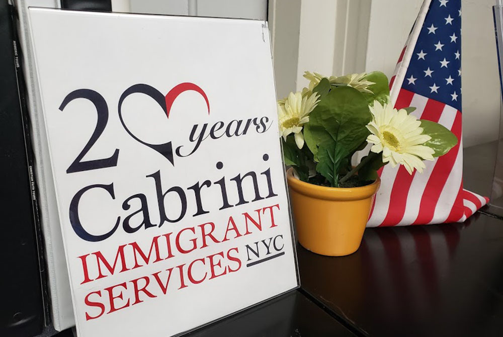 A display in the Lower East Side offices of Cabrini Immigrant Services notes last year's 20th anniversary of the social service agency, which offers a variety of services to immigrants. (GSR photo/Chris Herlinger) A display in the Lower East Side offices of Cabrini Immigrant Services notes last year's 20th anniversary of the social service agency, which offers a variety of services to immigrants. (GSR photo/Chris Herlinger)