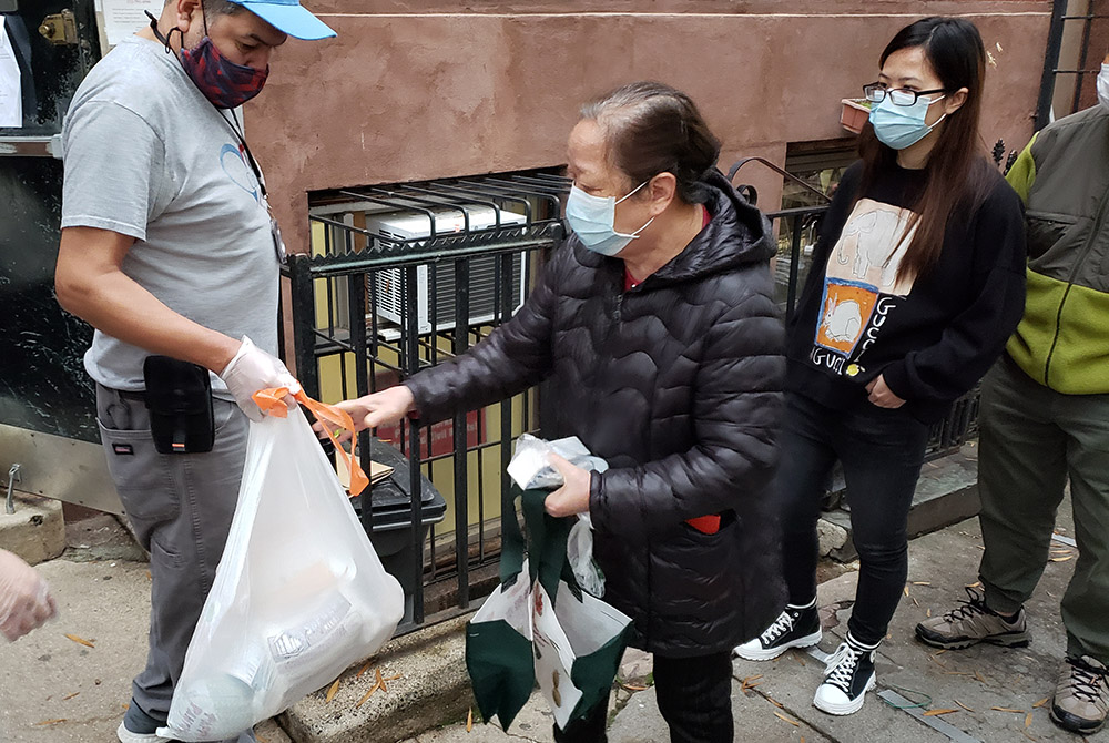 Those in line for food packages outside Cabrini Immigrant Services on Oct. 27 received a frozen chicken, milk, tea, rice, beans, potatoes and other vegetables. Many of those receiving the packages are elderly neighborhood residents of Chinatown, who thems Those in line for food packages outside Cabrini Immigrant Services on Oct. 27 received a frozen chicken, milk, tea, rice, beans, potatoes and other vegetables. Many of those receiving the packages are elderly neighborhood residents of Chinatown, who thems