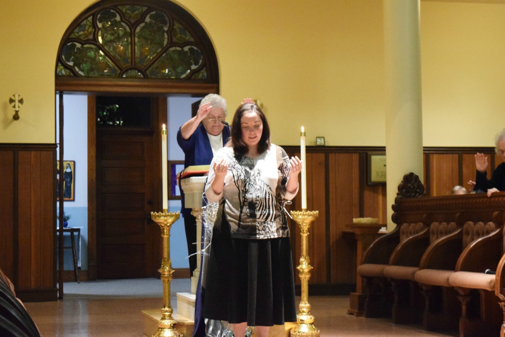 Sr. Esther Fangman, prioress of the Benedictine Sisters of Mount St. Scholastica of Atchison, Kansas, blesses Emily Bauer, 26, as she makes her vows as a canonical novice with the community Dec. 7, 2019. Sr. Esther Fangman, prioress of the Benedictine Sisters of Mount St. Scholastica of Atchison, Kansas, blesses Emily Bauer, 26, as she makes her vows as a canonical novice with the community Dec. 7, 2019.