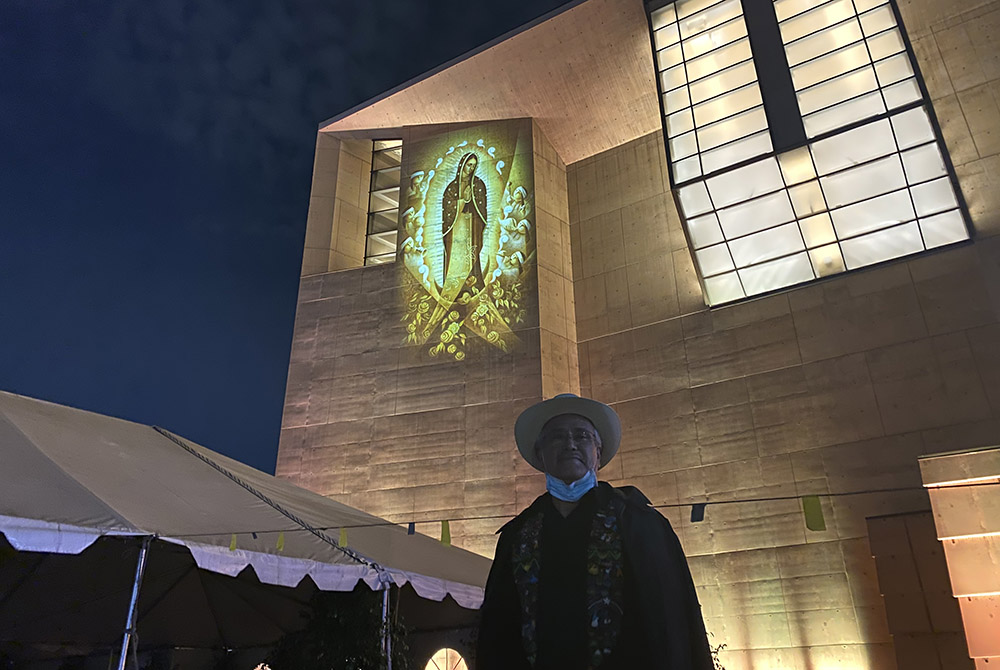 Artist Lalo Garcia stands in front of his 2013 painting of Our Lady of Guadalupe, Cihualpilli Tonantzin (“Noble Little Indian, Our Mother”), projected in light onto the outer wall of the Cathedral of Our Lady of the Angels, Dec. 9 in downtown Los Angeles. Artist Lalo Garcia stands in front of his 2013 painting of Our Lady of Guadalupe, Cihualpilli Tonantzin (“Noble Little Indian, Our Mother”), projected in light onto the outer wall of the Cathedral of Our Lady of the Angels, Dec. 9 in downtown Los Angeles.