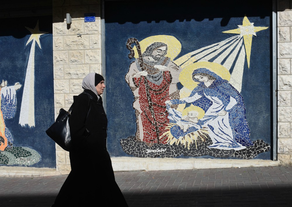 A Palestinian woman walks by a mosaic of the Nativity in Bethlehem, West Bank, Dec. 17, 2018. (CNS/Debbie Hill) A Palestinian woman walks by a mosaic of the Nativity in Bethlehem, West Bank, Dec. 17, 2018. (CNS/Debbie Hill)
