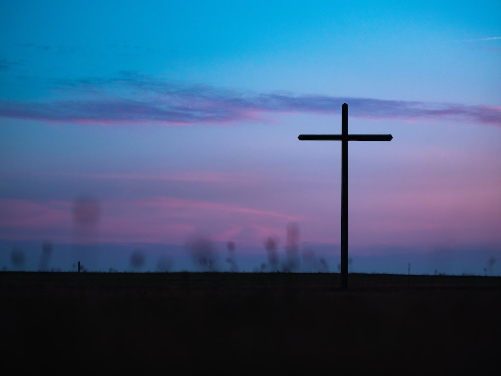 Cross seen in field during sunrise or sunset (Unsplash/Aaron Burden) Cross seen in field during sunrise or sunset (Unsplash/Aaron Burden)