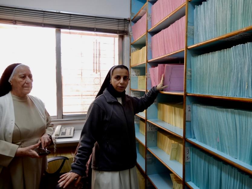 Dominican Sr. Habiba Toma Binham, left, and Sr. Maryan Nahla Kame in the records room of the Pontifical Mission clinic in Zarqa, are refugees themselves, having fled Iraq in 2014. Dominican Sr. Habiba Toma Binham, left, and Sr. Maryan Nahla Kame in the records room of the Pontifical Mission clinic in Zarqa, are refugees themselves, having fled Iraq in 2014.