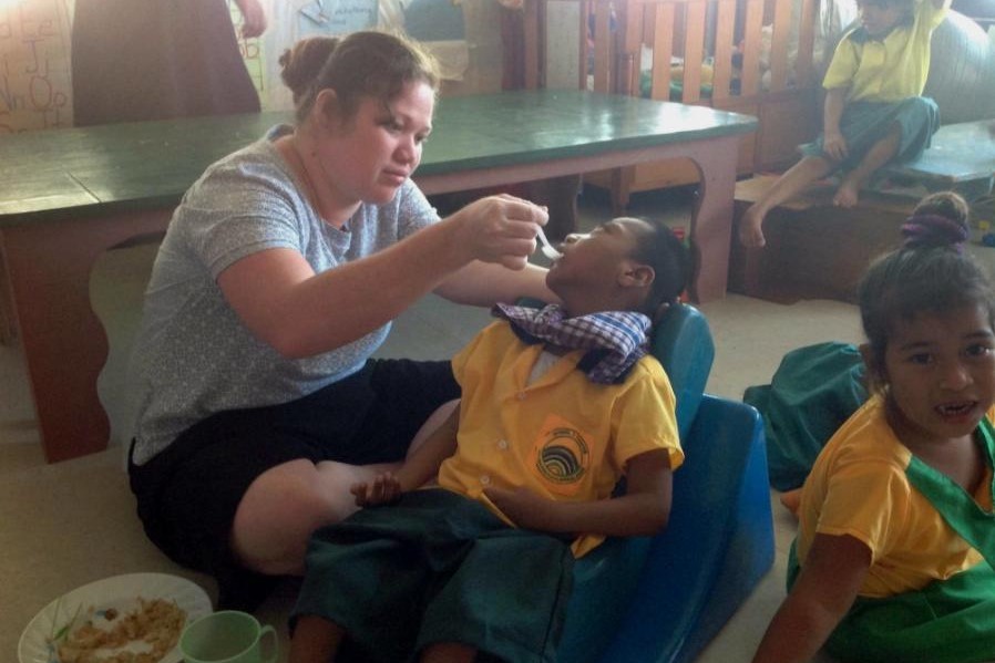 Sr. Kawi Arebonto feeds a child who lives with disabilities. Sr. Kawi Arebonto feeds a child who lives with disabilities.