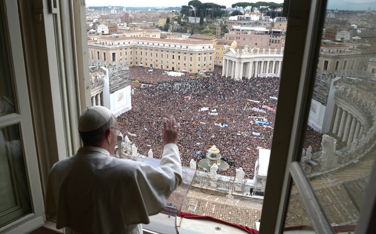 Pope Francis waves to the crowd from the window of his private apartment as he leads his first Angelus in St. Peter's Square at the Vatican March 17, 2013. (CNS/L'Osservatore Romano)