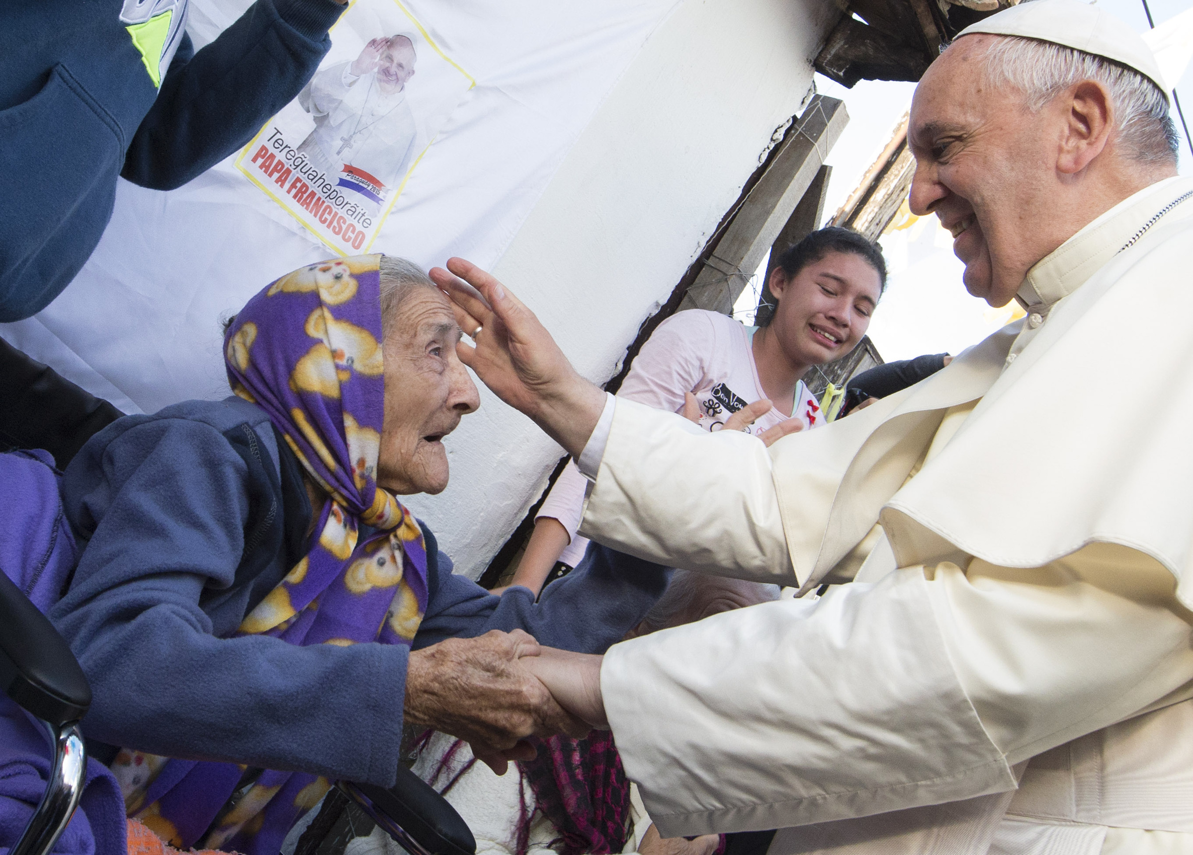 ope Francis greets an elderly woman as he meets with people of Banado Norte, a poor neighborhood in Asuncion, Paraguay, July 12. (CNS/Paul Haring)